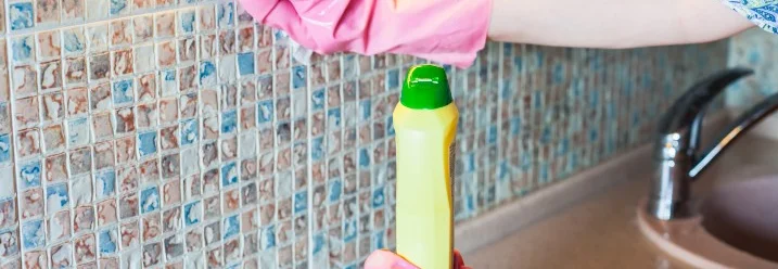 Person reinigt Fliesen mit Tuch.